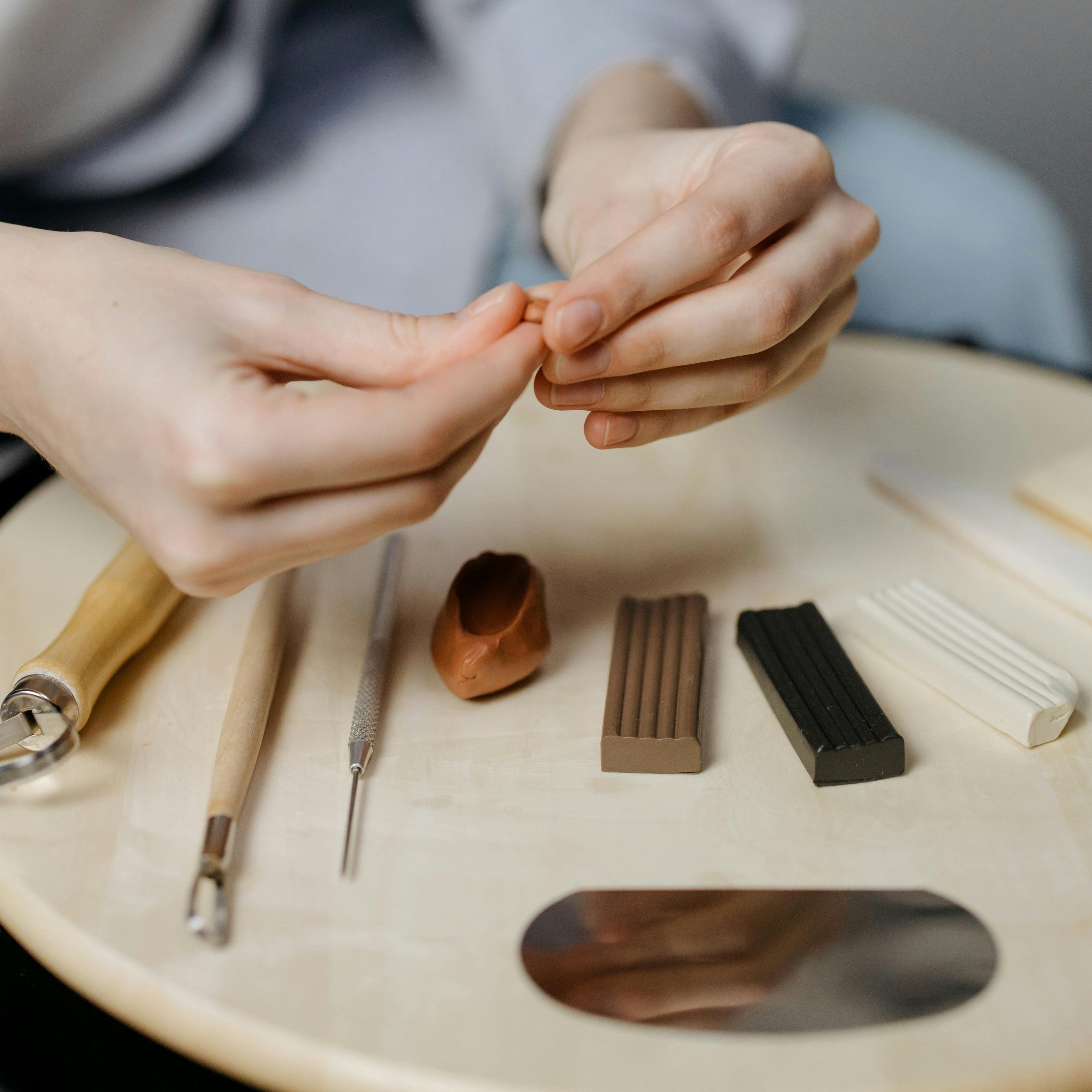 Mains qui travaillent un morceau d'argile polymère.