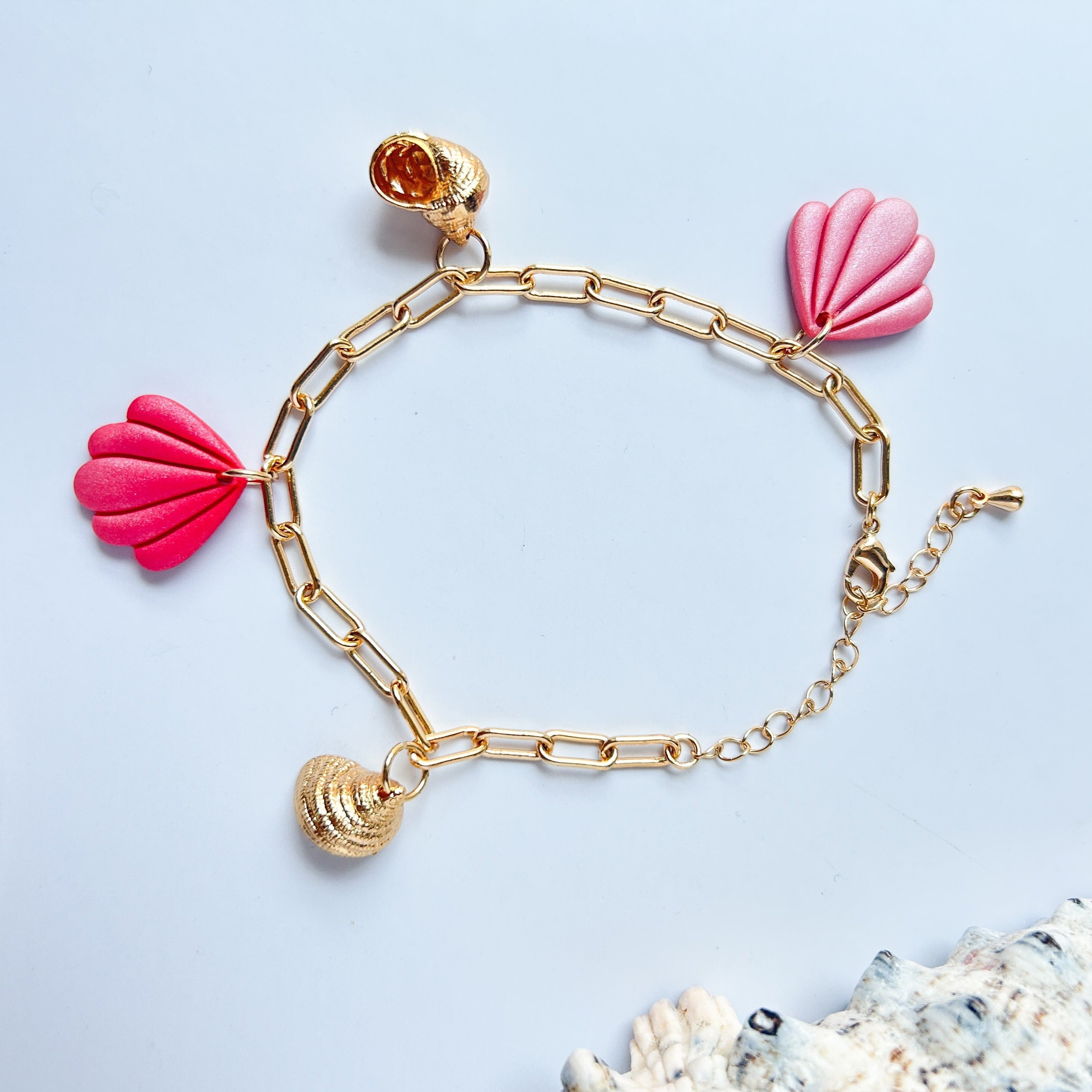 Bracelet en acier inoxydable plaqué or avec breloques de coquillages en argile polymère et en acier inoxydable.