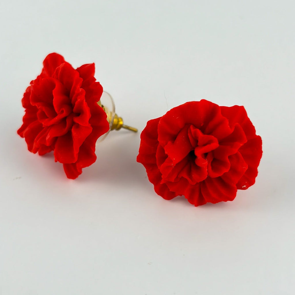 Boucles d’oreilles Œillets – Rouge vif : deux œillets rouge vif sculptés, posés sur fond clair