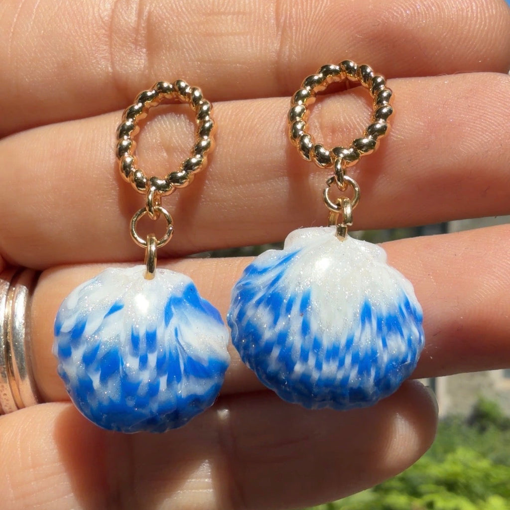 Boucles d’oreilles Galite – Perle d’écume : coquillages bleu et blanc avec perles, gros plan tenu dans la main