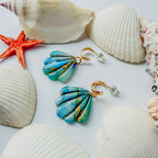 Boucles d’oreilles Laguna – Coquillage sculpté : coquillages bleu lagon marbrés d’or, posés parmi des coquillages