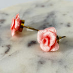 Boucles d’oreilles Roses Passion – Rose poudre métallique : roses rose poudre métallisées, vue de face et de profil sur marbre