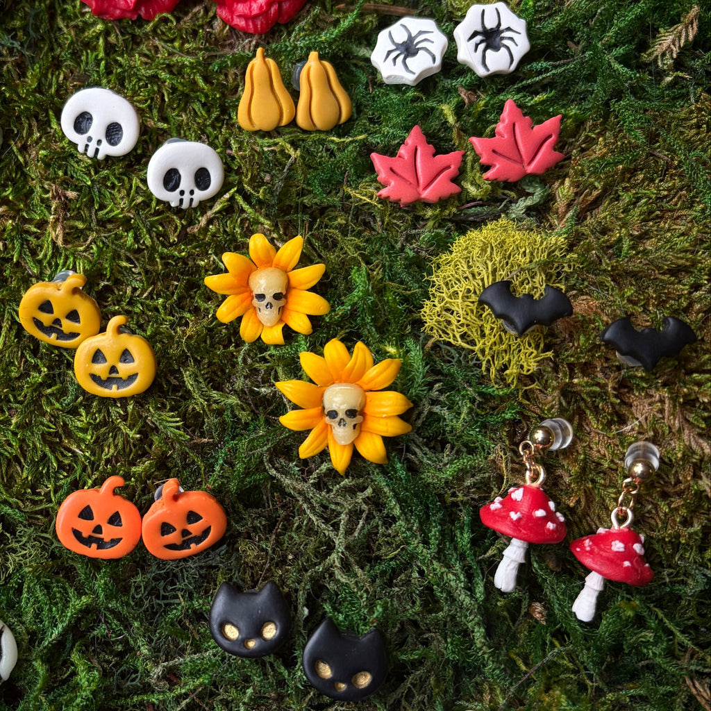 Sélection de bijoux d’automne et d’Halloween sur la mousse, avec des boucles d’oreilles amanites rouges.