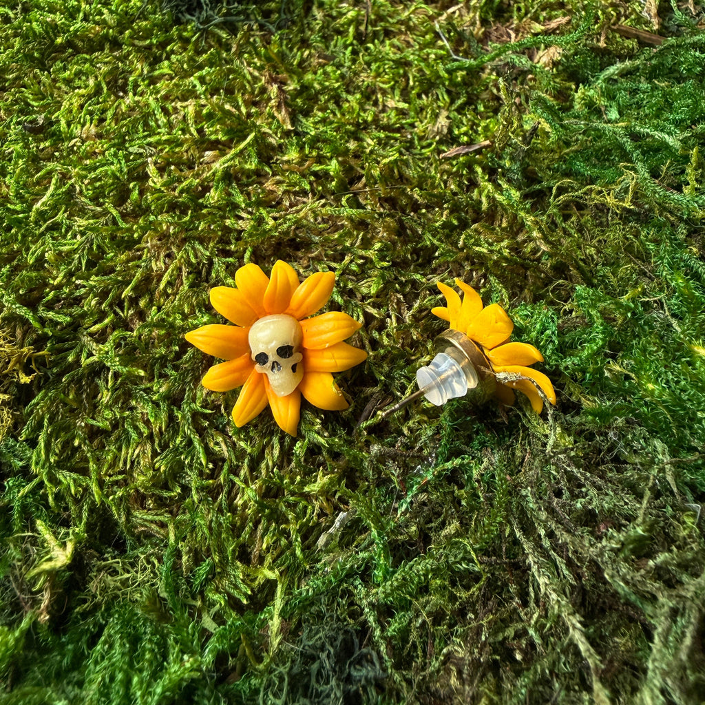 Puces tournesols à crânes en argile polymère sur la mousse, avec une vue de profil et d’une poussette.