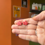 Paire de puces feuilles d’érable aux nervures en relief, présentée dans une main.