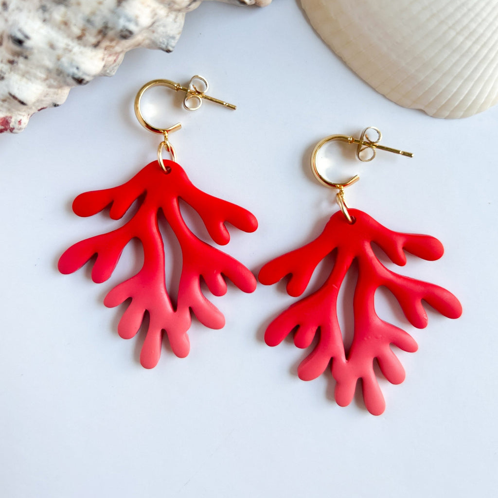 Boucles d’oreilles Coraux Morjane : branches de corail rouges et roses suspendues à des anneaux, sur fond blanc