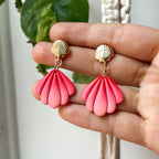 Boucles d’oreilles Laguna – Coquillage sculpté : coquillages rose corail en éventail sur attaches dorées, tenus dans la main