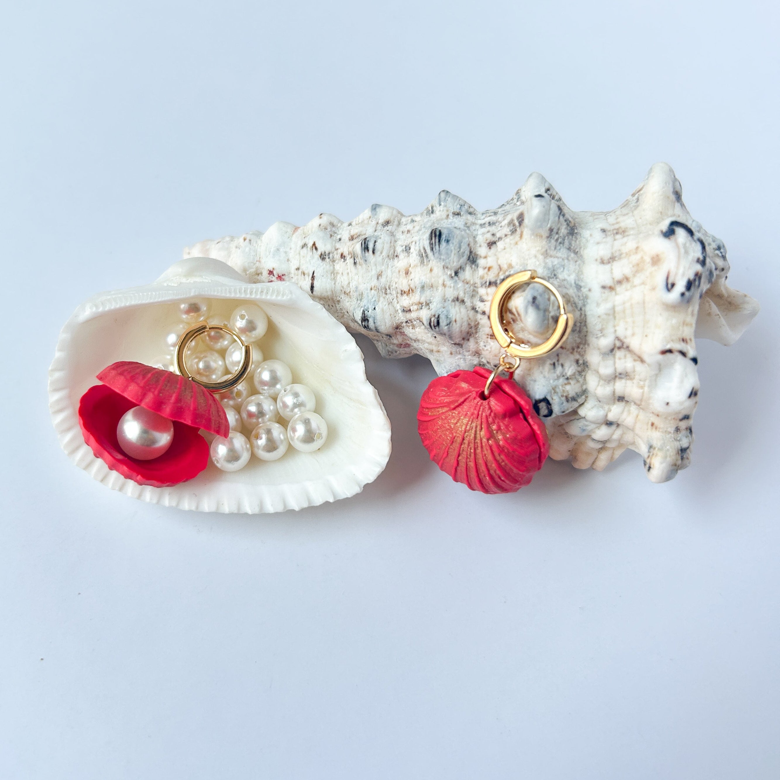 Boucles d’oreilles Perla del Mare – Coquillage à perle : coquillages rouge corail et orange avec perles, présentés dans des coquilles